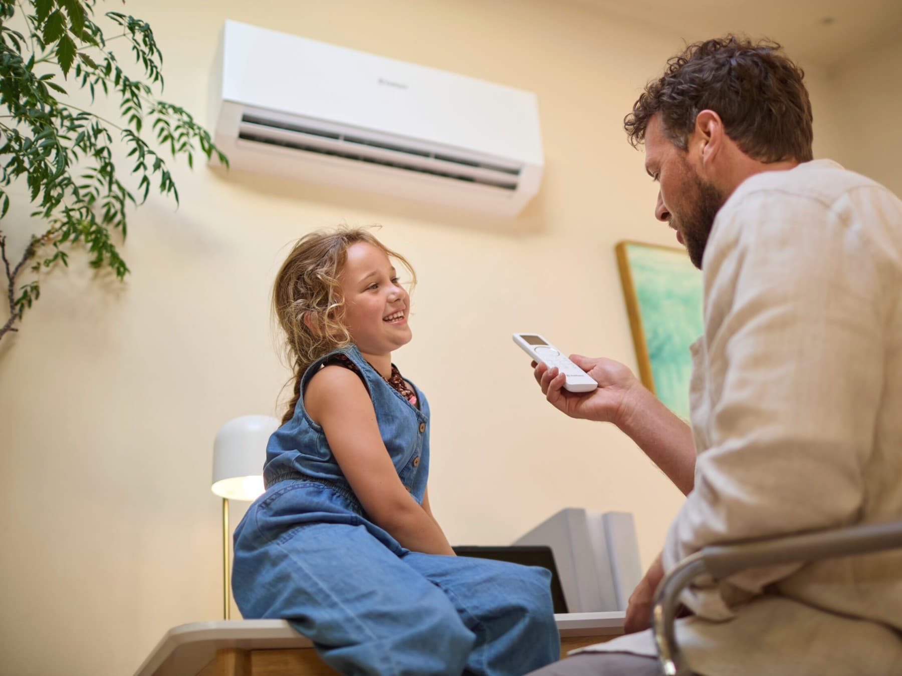 Tatal si fiica lui in fata unui aparat de aer conditionat Vaillant