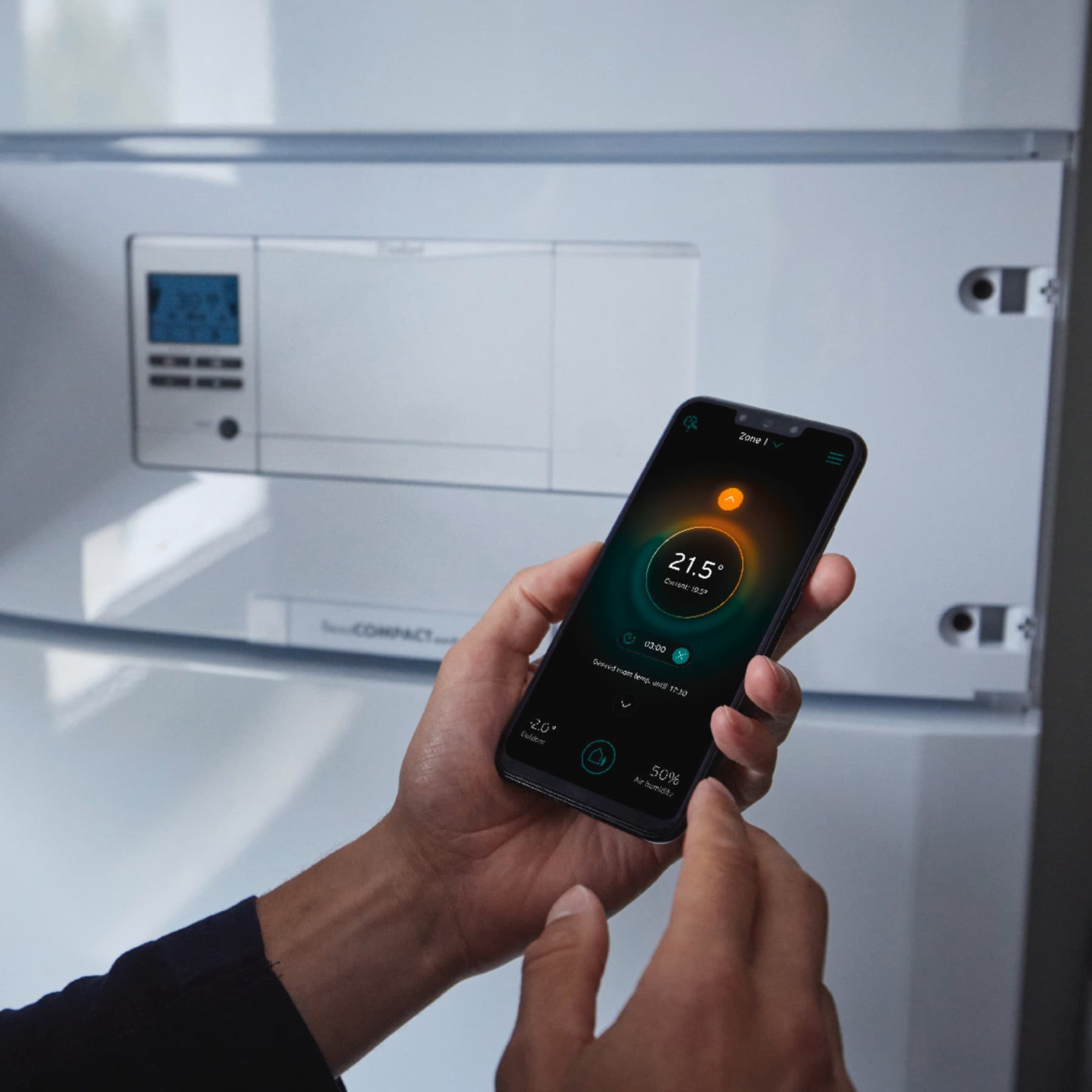 Un barbat care regleaza temperatura de pe telefonul sau
