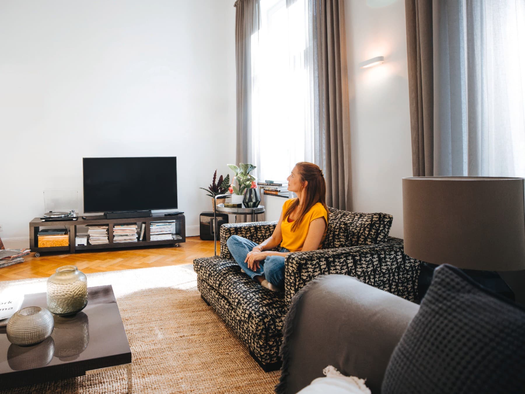 Femeie intr-un apartament, pe o canapea