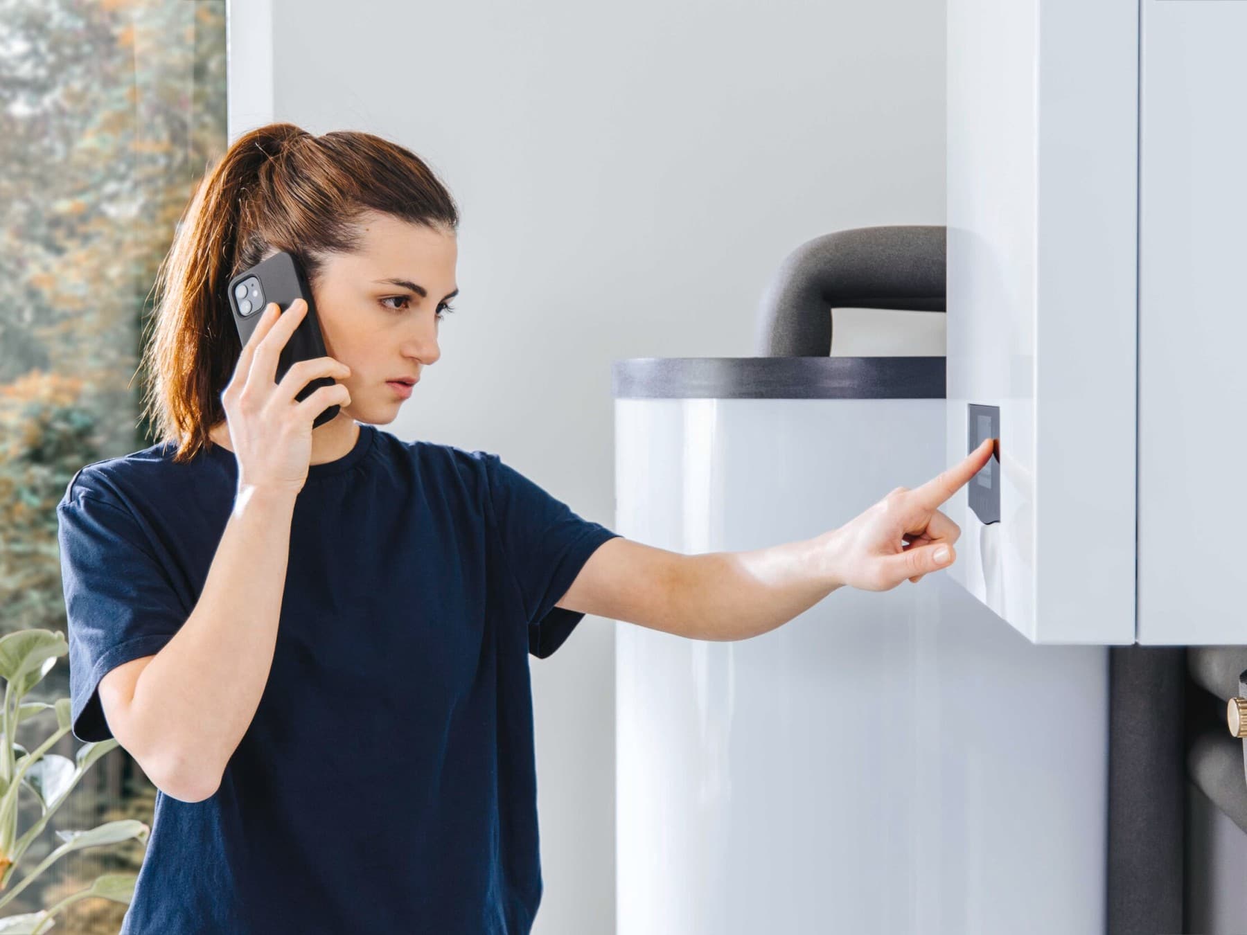 O femeie vorbeste la telefon si verifica setarile centralei