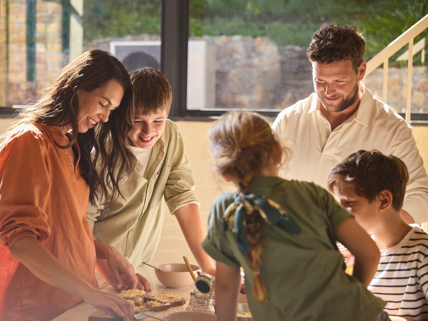 O familie taie un tort in bucataria lor