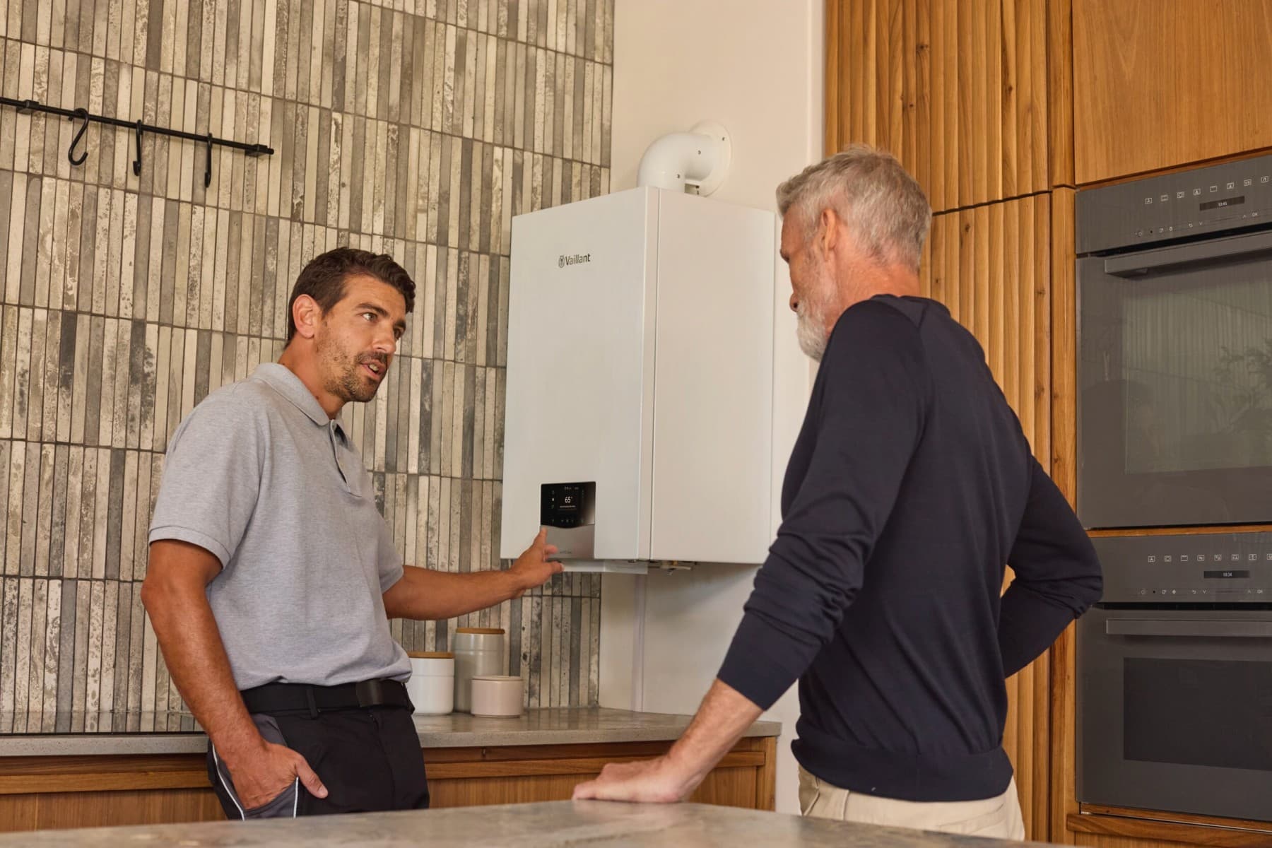 Partenerul Vaillant arata catre centrala si ii explica unui client