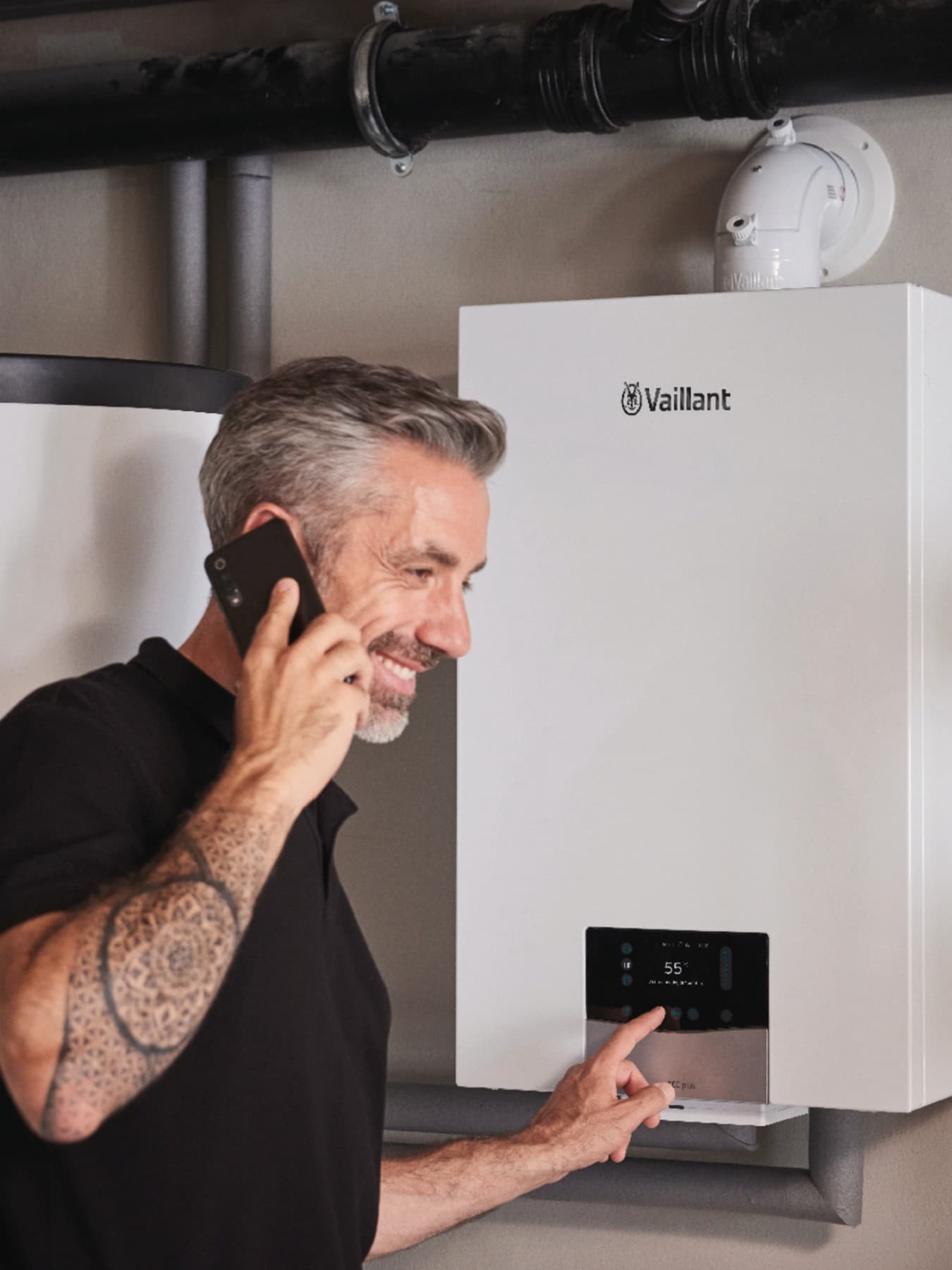 Barbat care vorbeste la telefon si regleaza setarile centralei ecoTEC plus