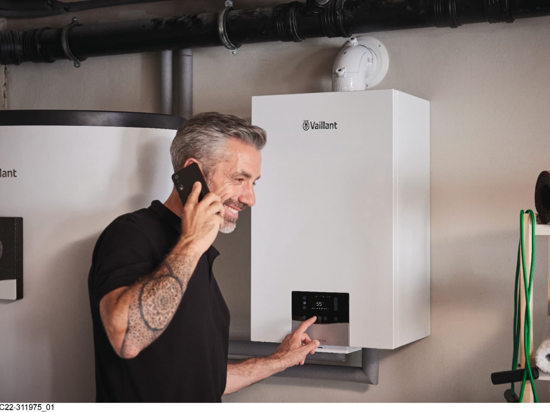 Barbat care vorbeste la telefon si regleaza setarile centralei ecoTEC plus