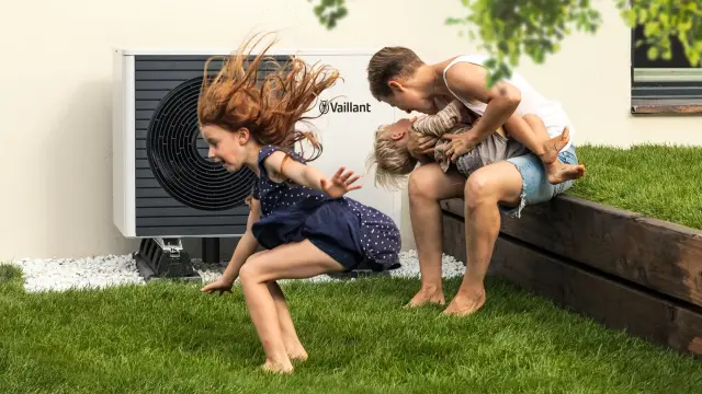 Pompă de căldură într-o grădină și mama se joacă cu copilul ei Pompă de căldură într-o grădină și mama se joacă cu copilul ei
